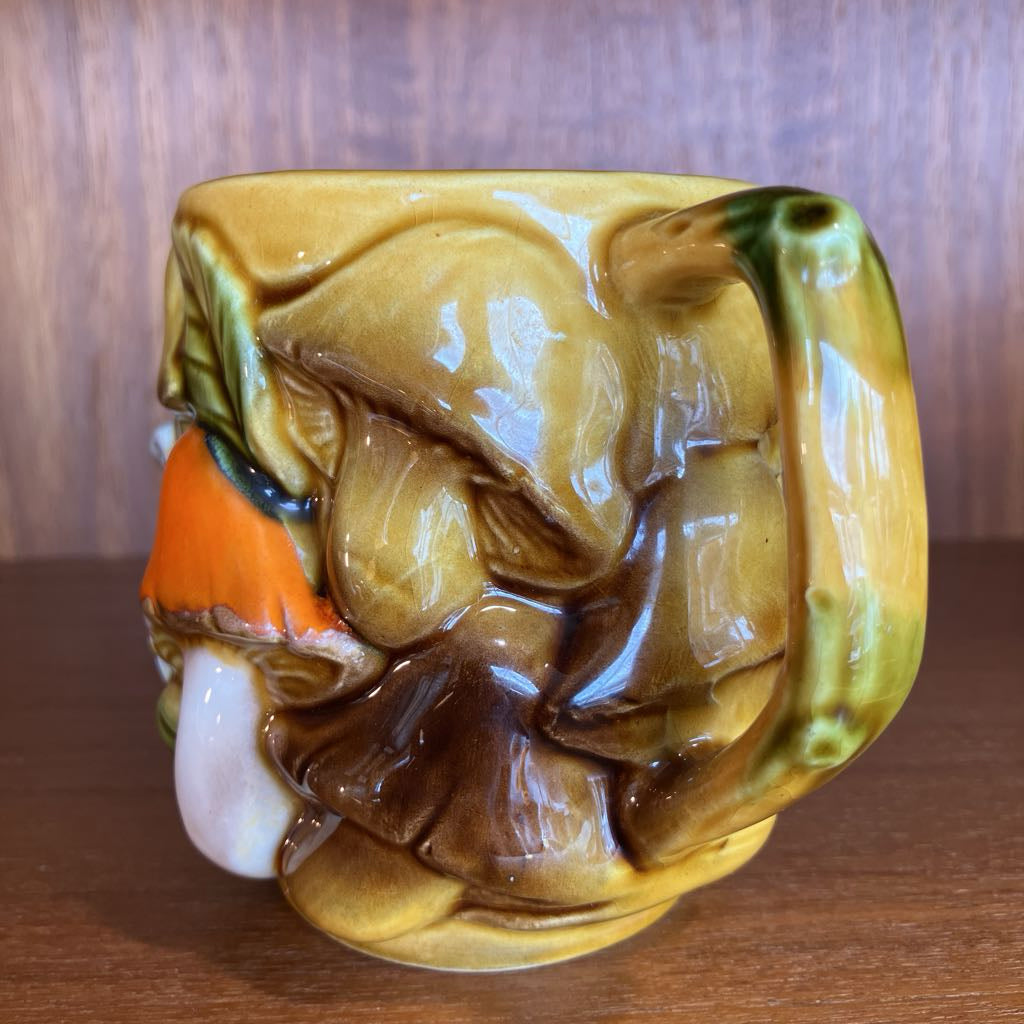 Ceramic mug with a mushroom design on a wooden surface