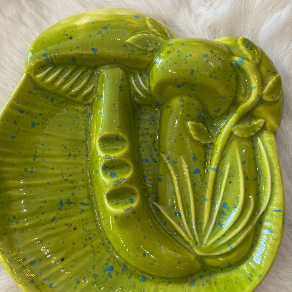 Green ceramic ashtray with a mushroom design on a white background