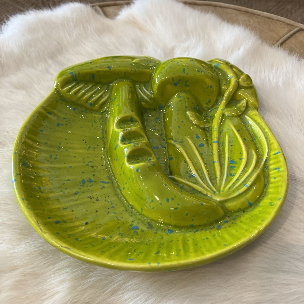 Green ceramic dish with a mushroom design on a white fur surface