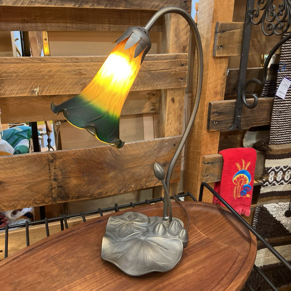 Decorative lamp with a glass shade on a wooden surface, surrounded by rustic wooden furniture.