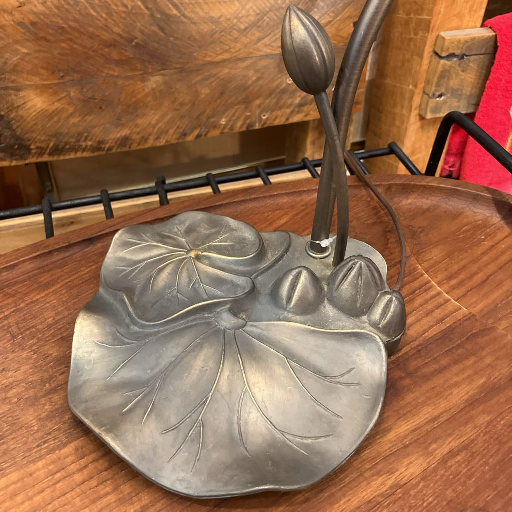 Metallic lily pad design on a wooden surface