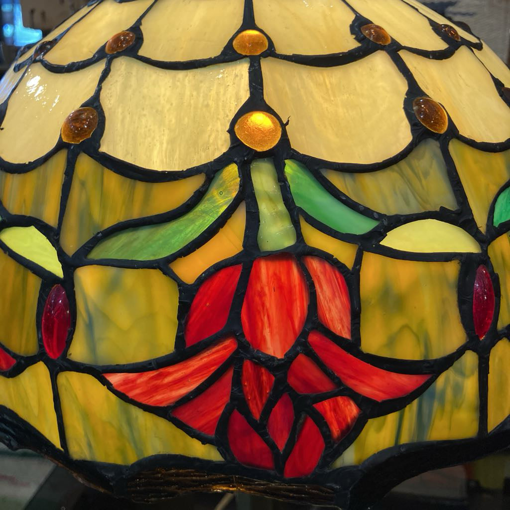 Stained glass lamp with floral design featuring red, green, and yellow colors.
