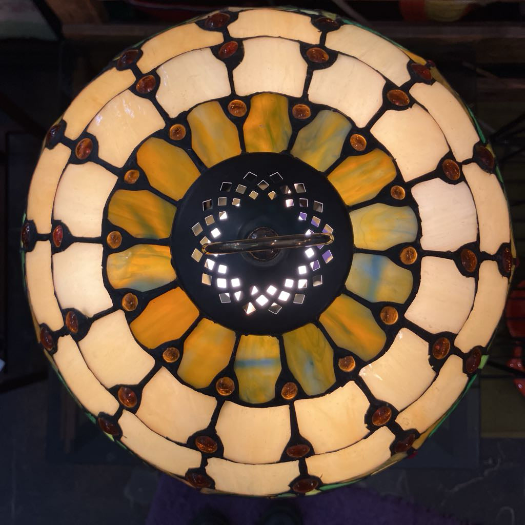 Decorative stained glass lamp with a circular design on a dark background