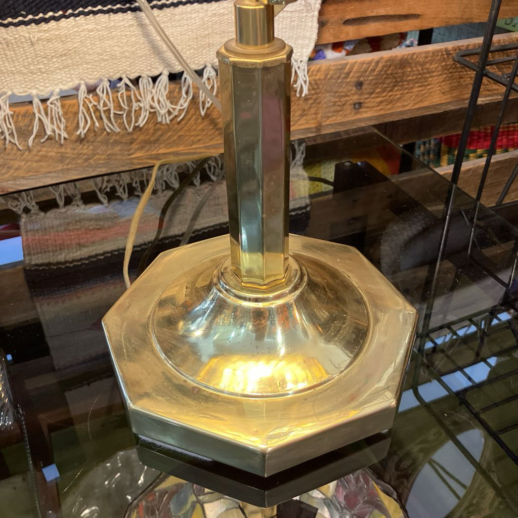 Gold lamp with hexagonal base on a reflective surface