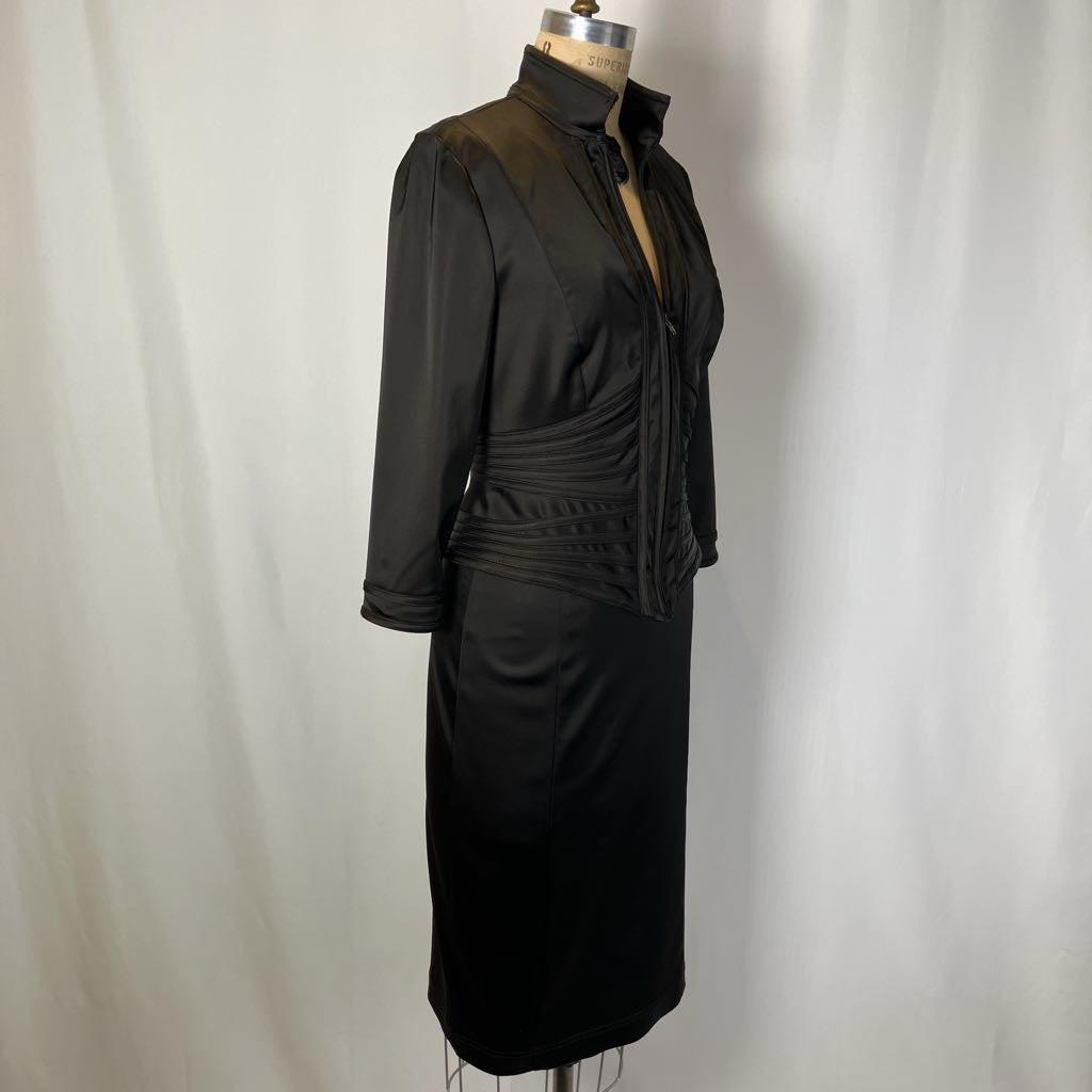 Black dress on a mannequin against a plain background