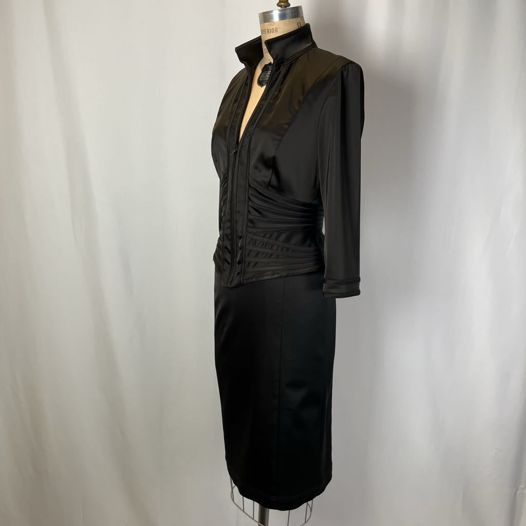 Black dress on a mannequin against a plain background