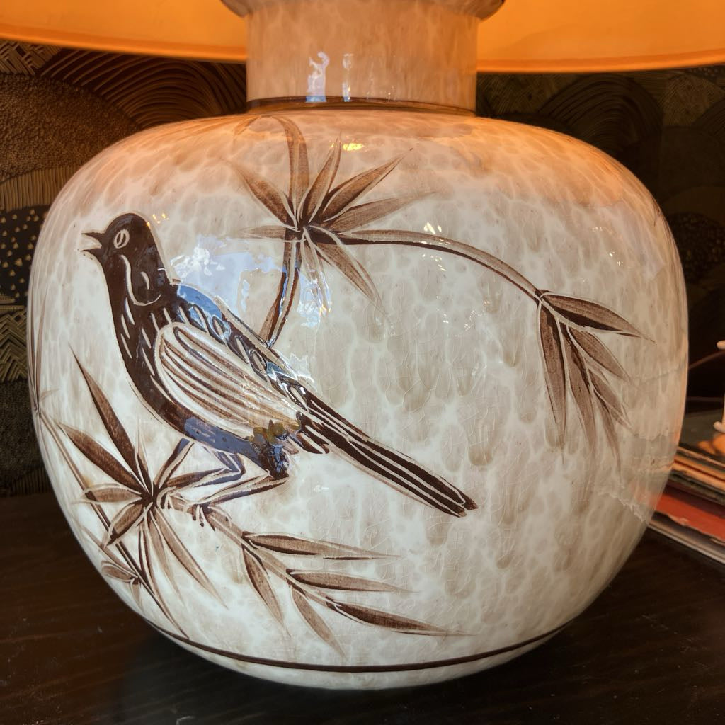 Ceramic lamp base with bird and leaf design on a textured surface