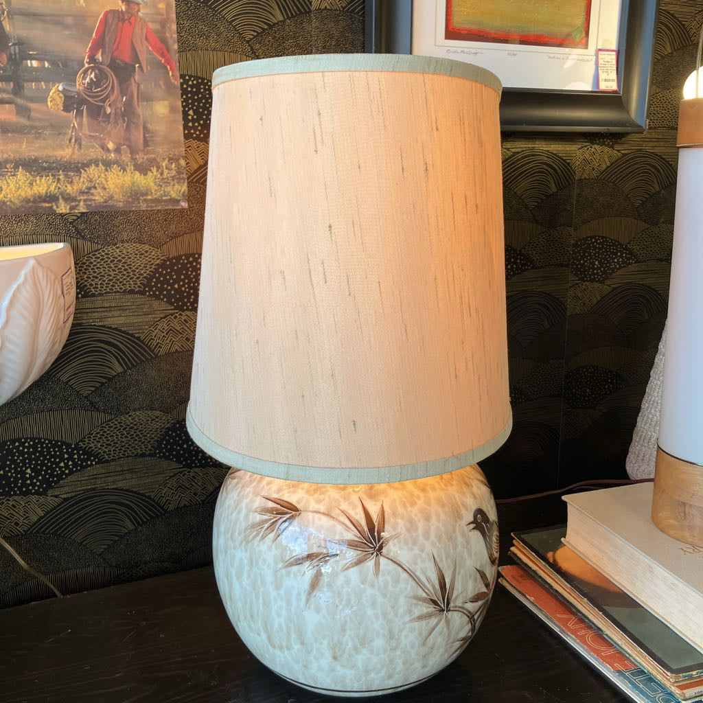 Decorative lamp with a textured base and wooden shade on a surface.