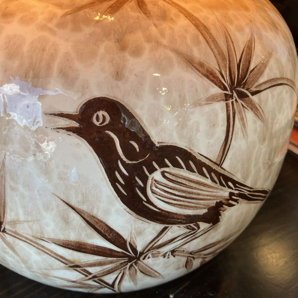 Decorative ceramic plate with a bird design on a textured surface