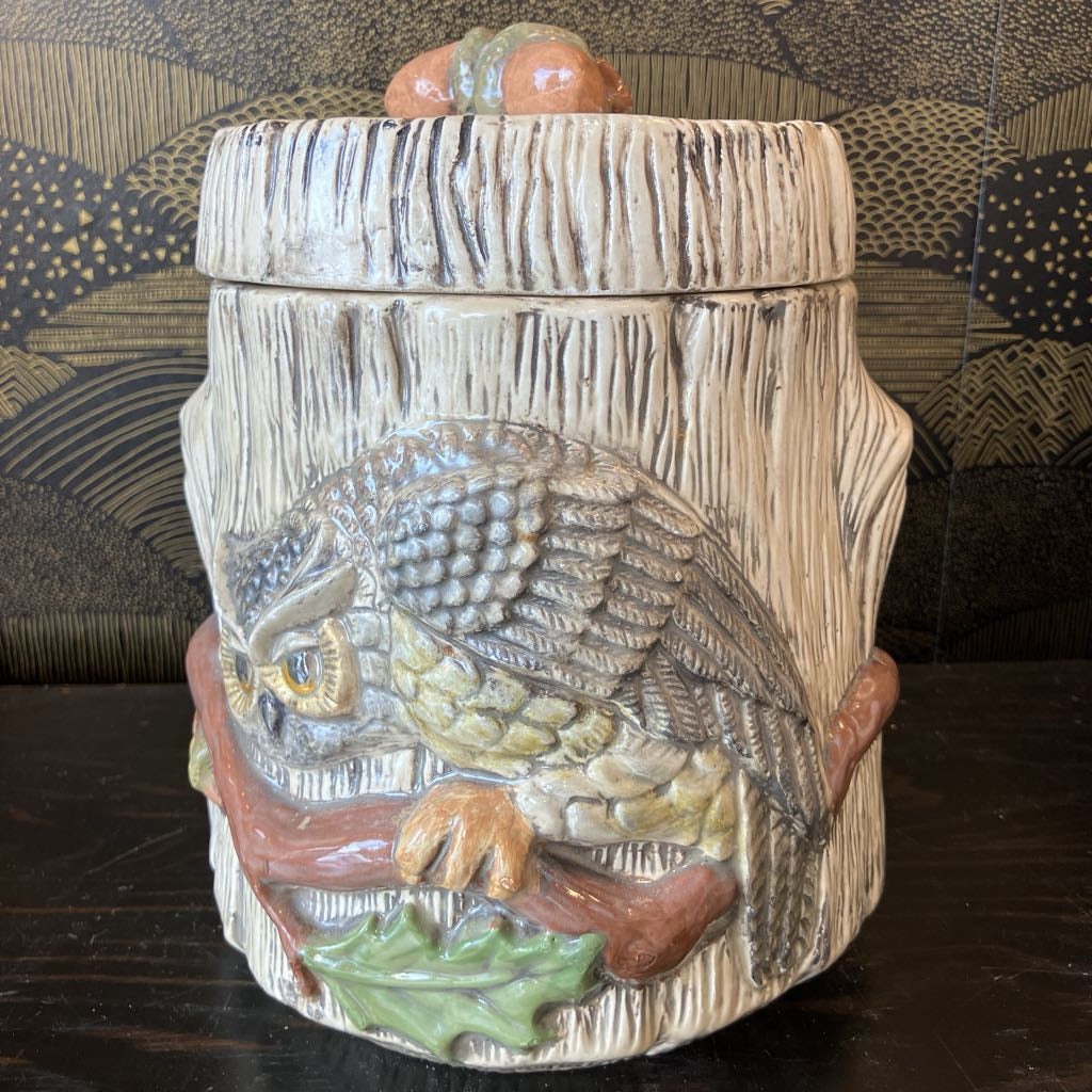 Decorative ceramic jar with owl design on a wooden surface
