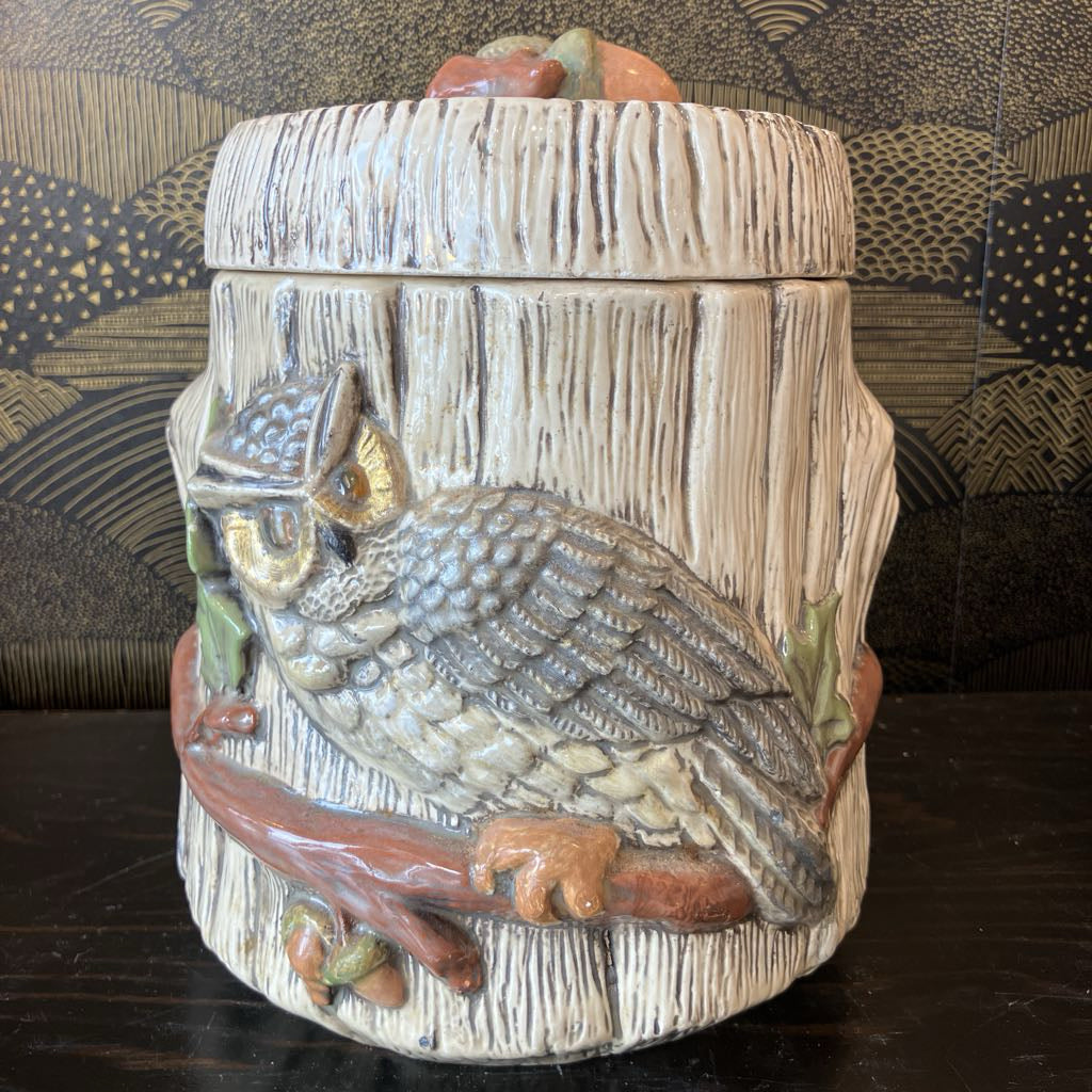 Decorative jar with an owl design on a wooden surface