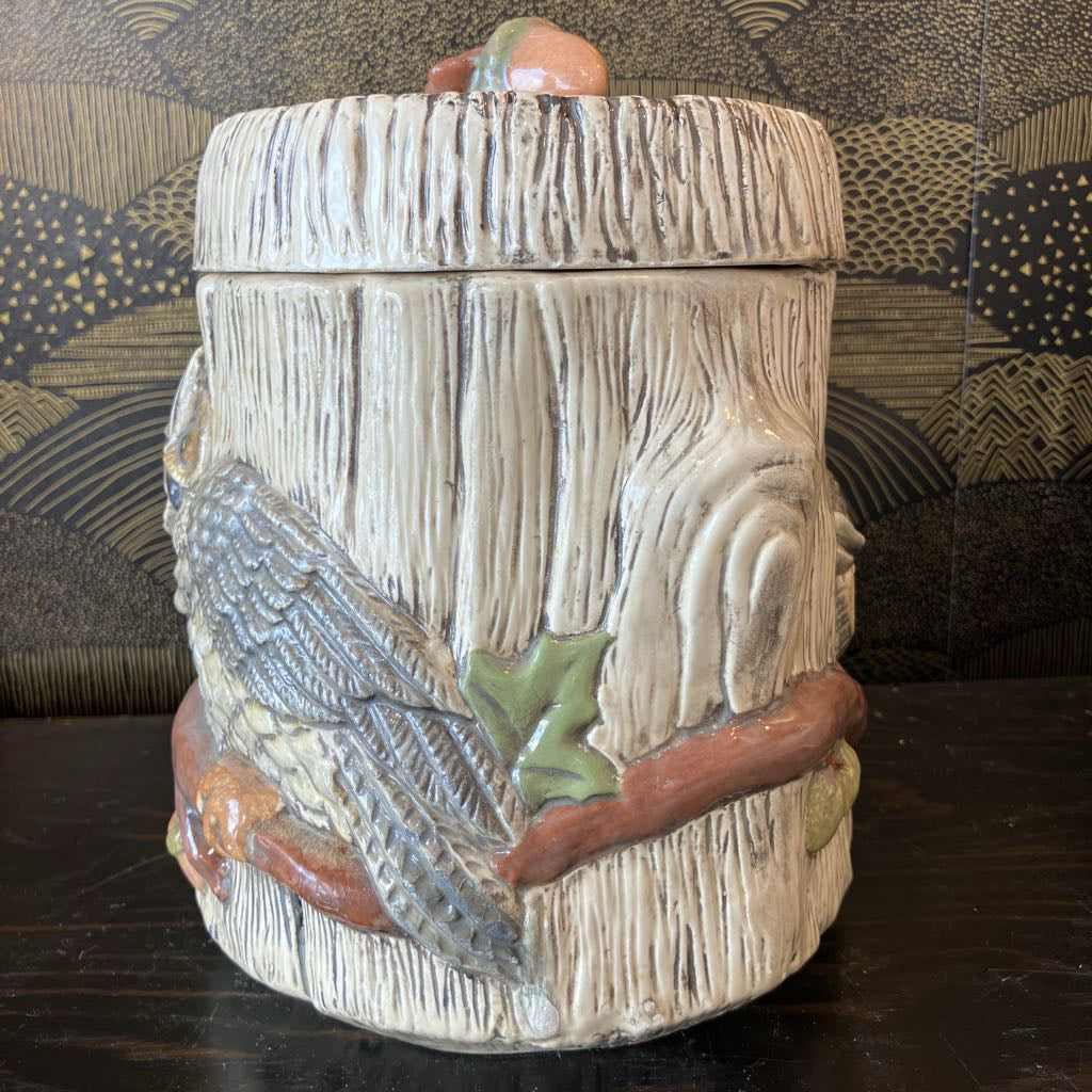 Decorative ceramic container with a bird design on a dark surface