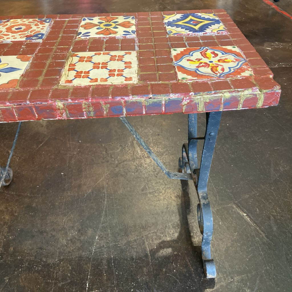 Colorful tiled table with decorative patterns on a dark floor.