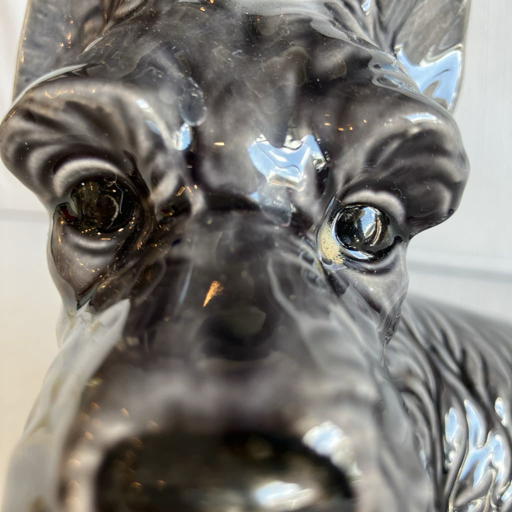 Close-up of a ceramic dog figurine with a detailed face.