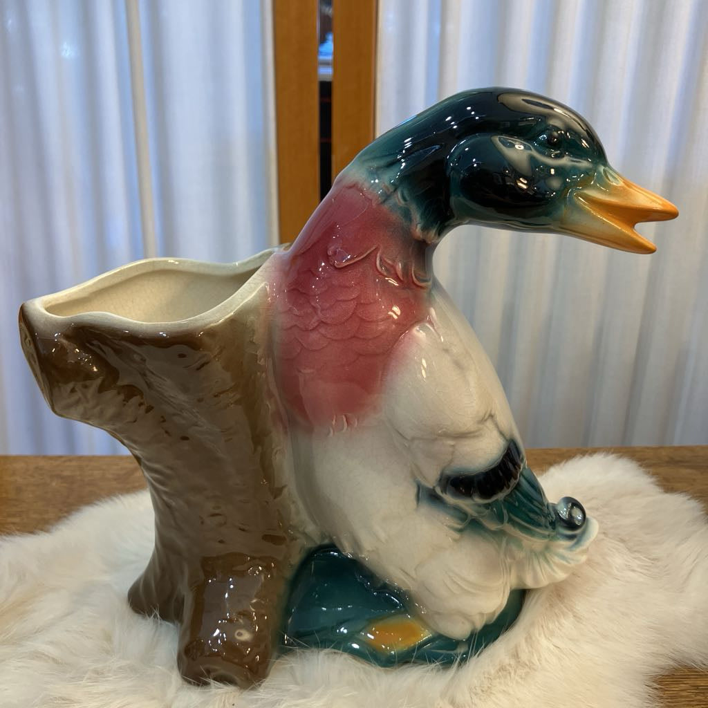 Ceramic duck-shaped planter on a white surface with a blurred background