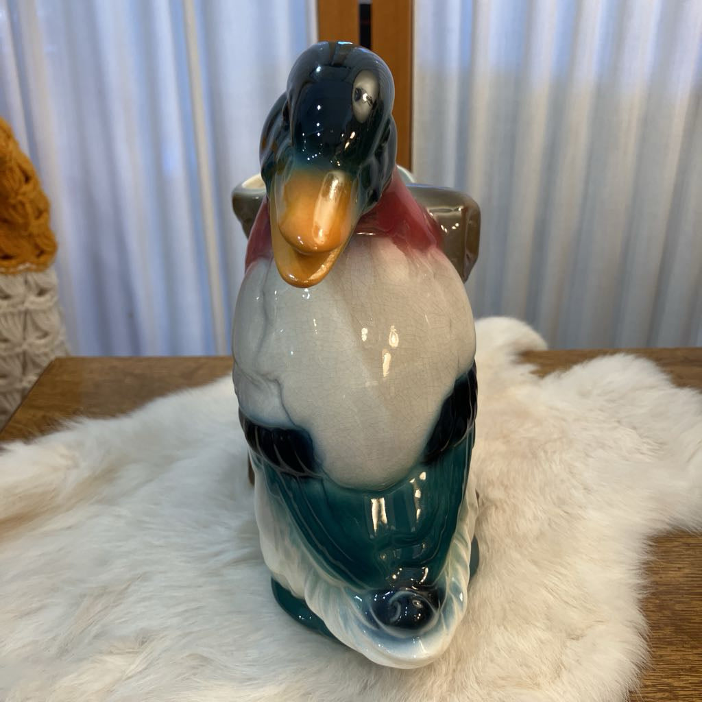 Duck-shaped ceramic jar on a fur surface with a blurred background