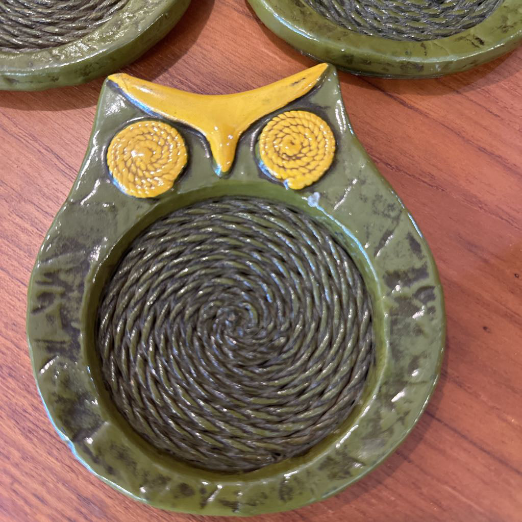 Ceramic owl-shaped trivet with spiral design on a wooden surface