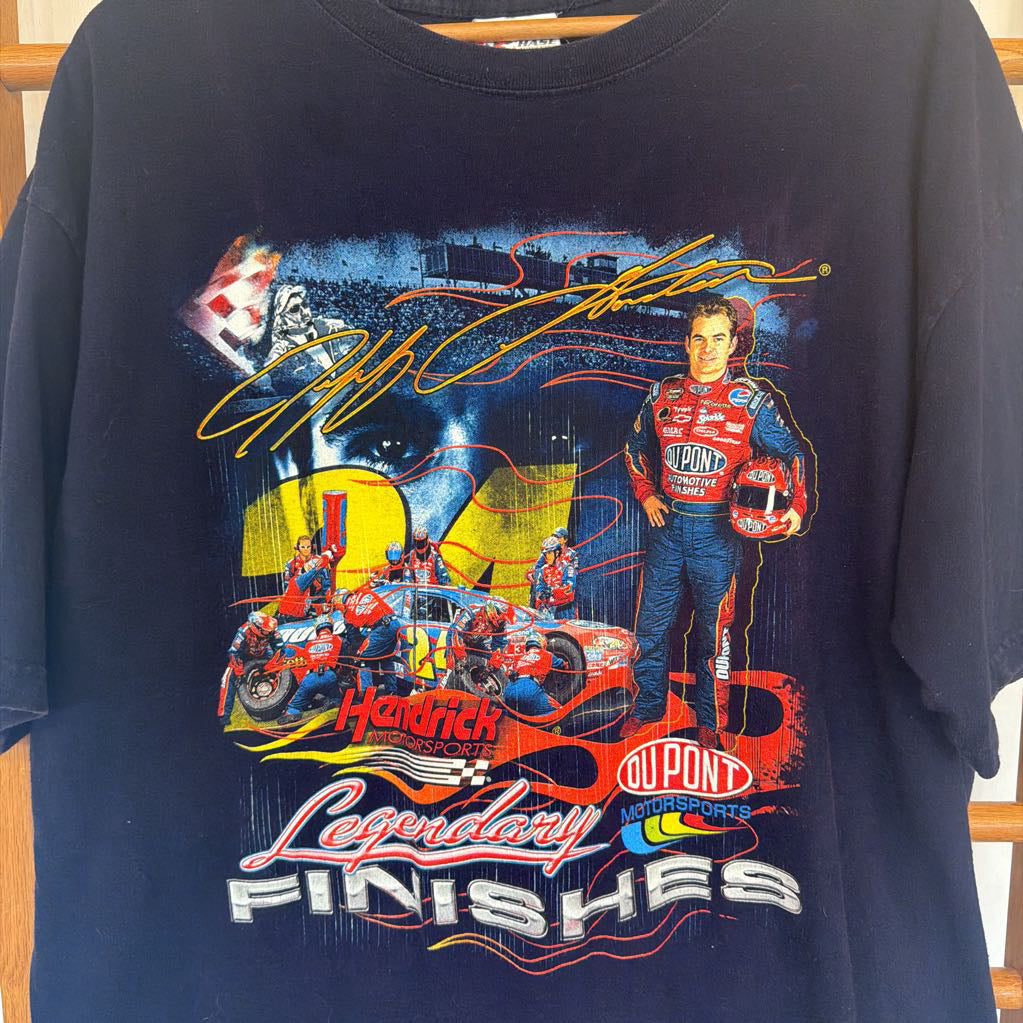 Navy blue t-shirt with racing-themed graphic and text on a wooden surface.