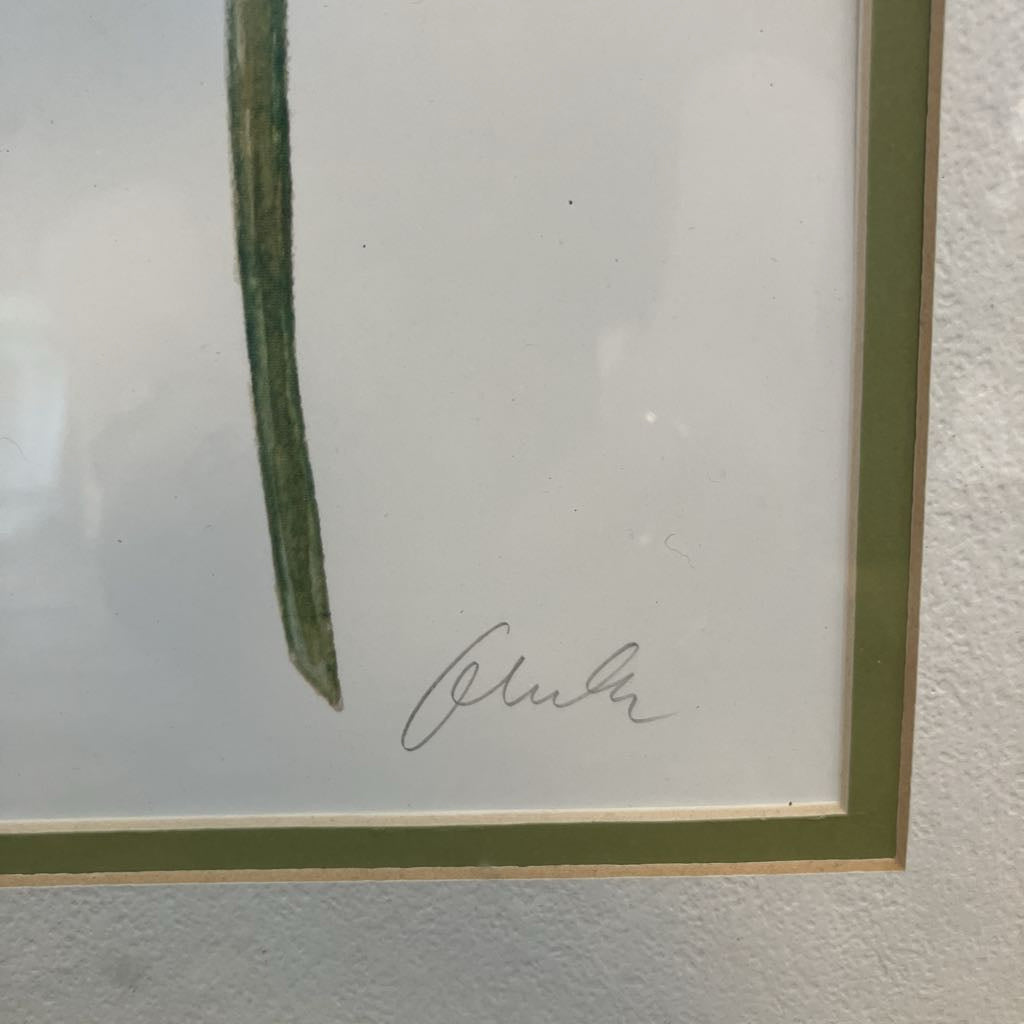 Framed artwork with a signature on a textured white surface