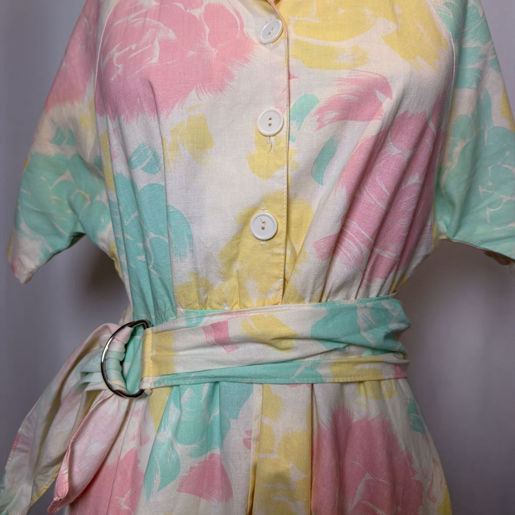 Pastel floral dress with a belt on a plain background