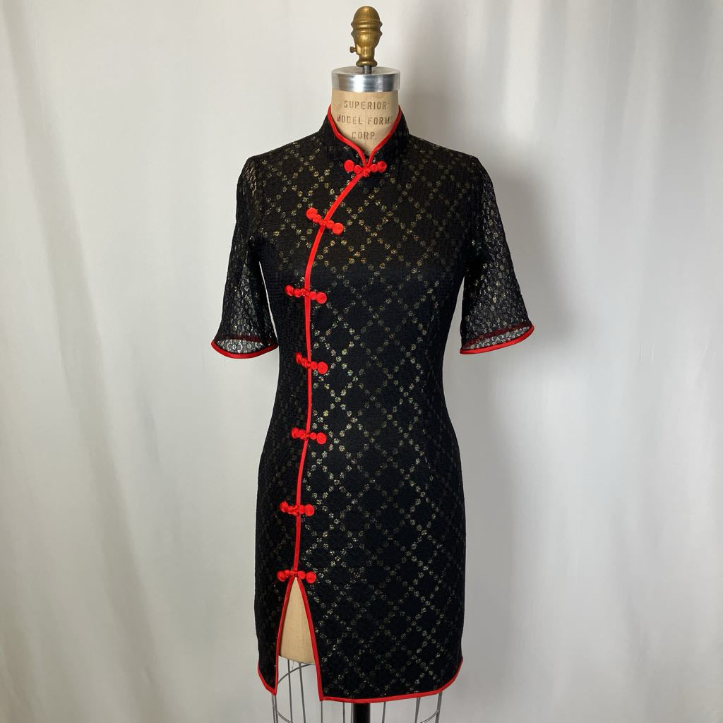 Black dress with red accents on a mannequin against a white background