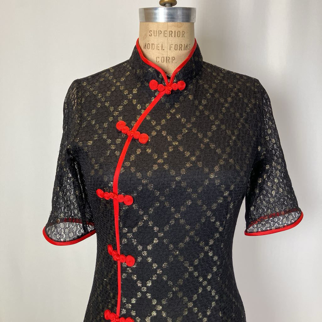 Black patterned dress with red accents on a mannequin against a white background