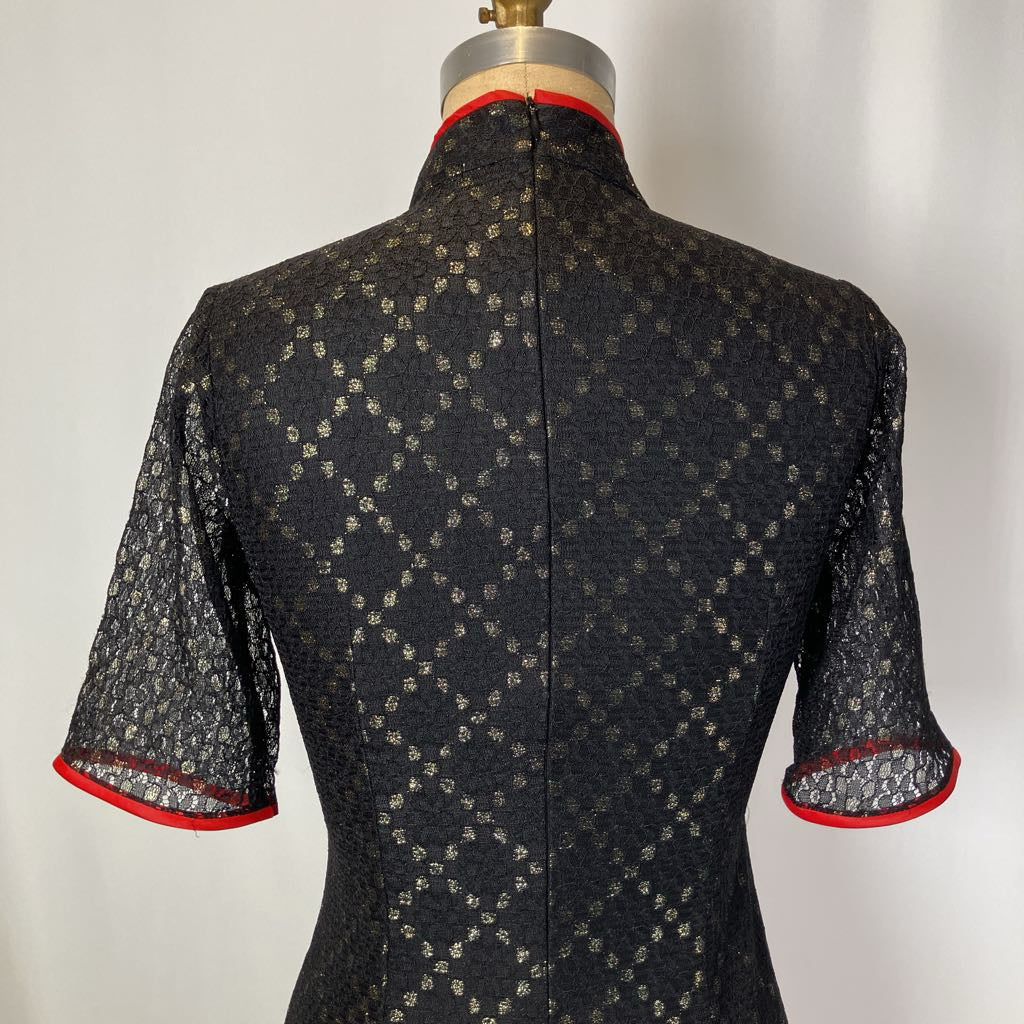 Black patterned dress on a mannequin against a white background