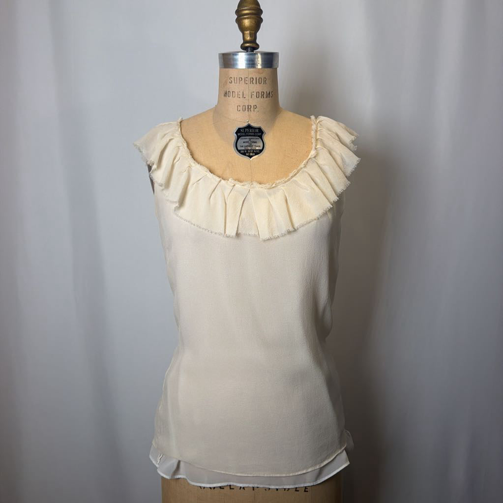 Beige blouse with ruffled neckline on a mannequin against a plain background