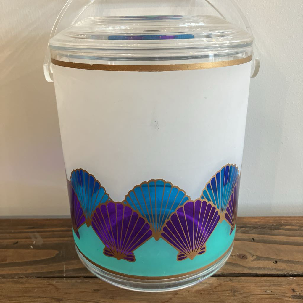Decorative plastic jar with shell pattern on a wooden surface