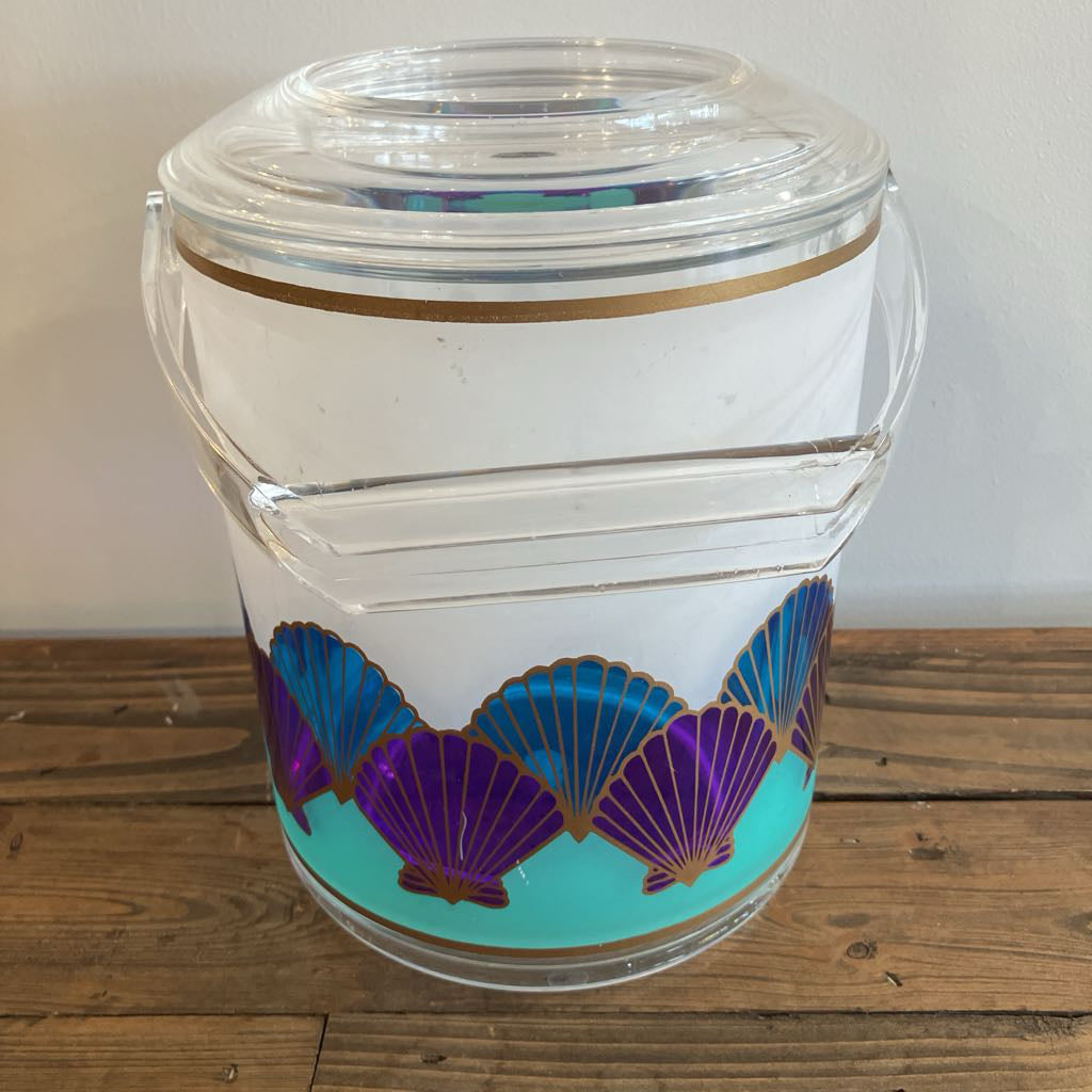 Clear plastic container with purple and blue shell designs on a wooden surface