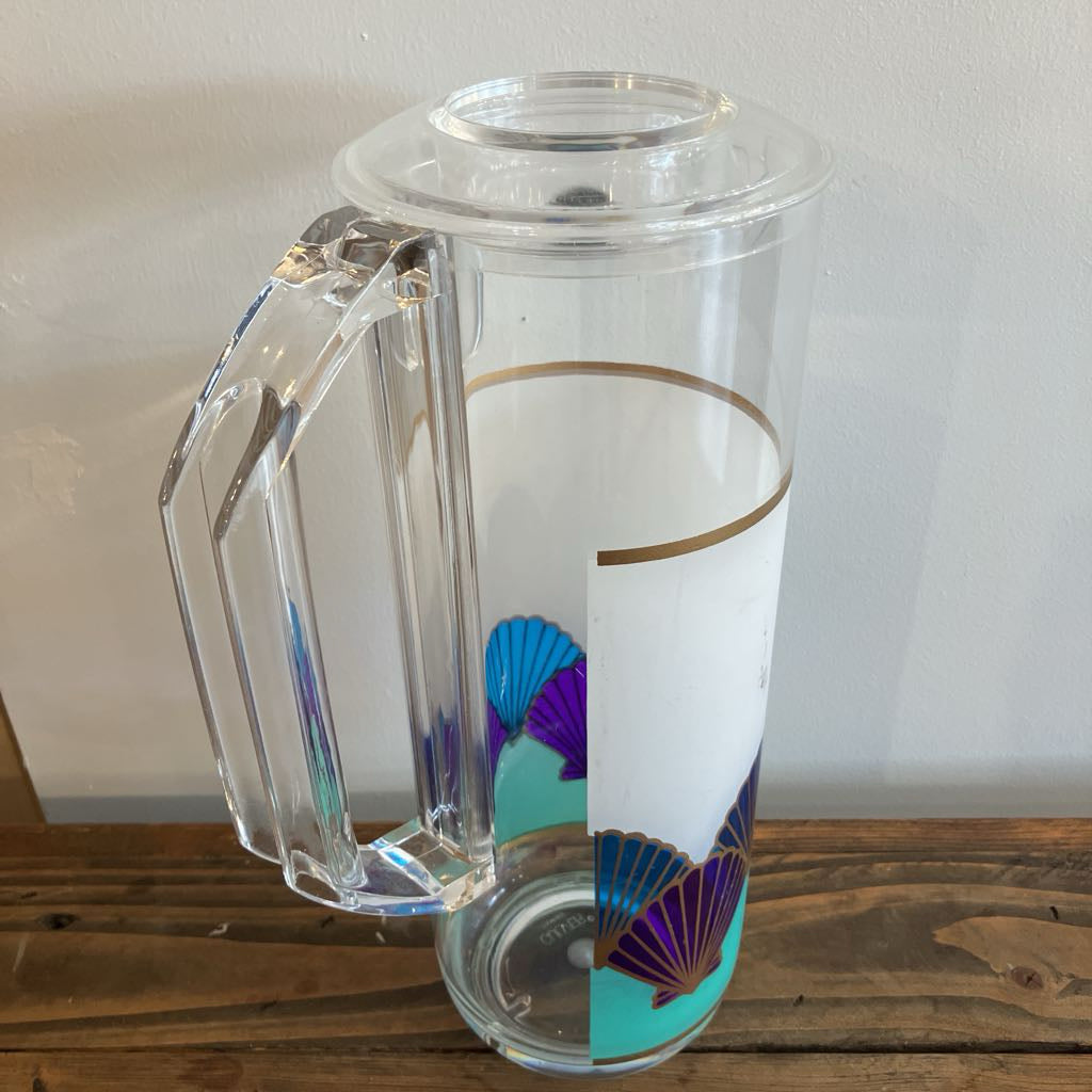 Clear pitcher with colorful design on a wooden surface