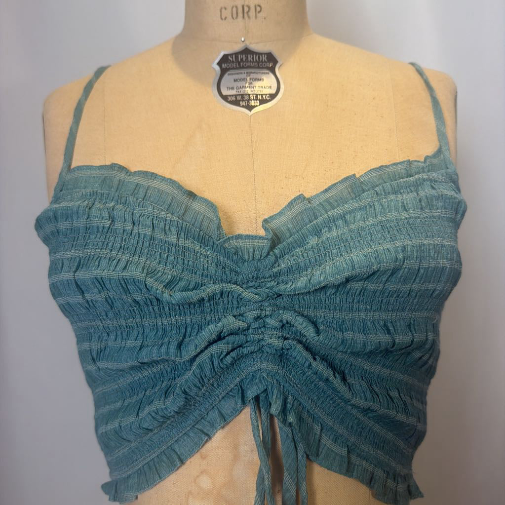 Blue textured top on a mannequin with a gray background