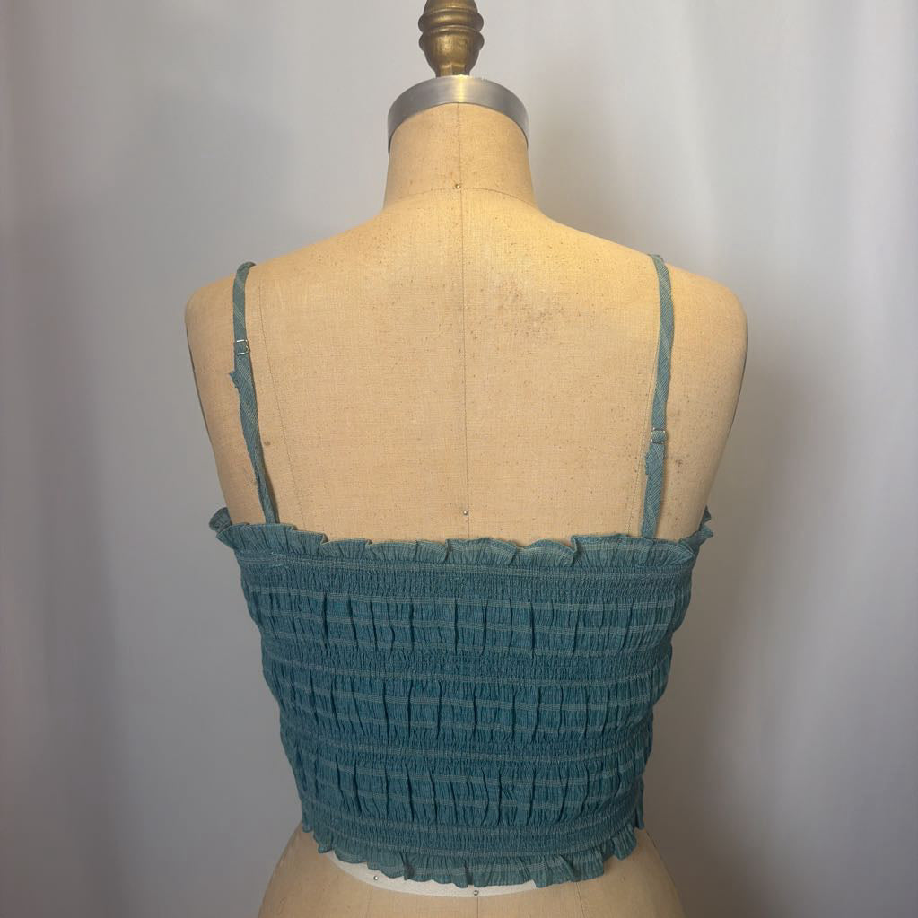 Teal top on a mannequin against a plain background