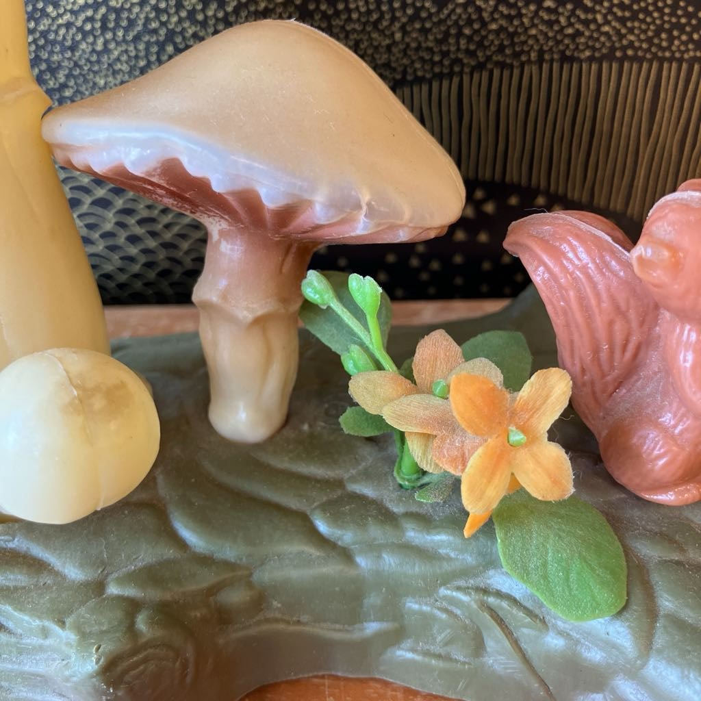 Decorative item with mushrooms and flowers on a textured surface