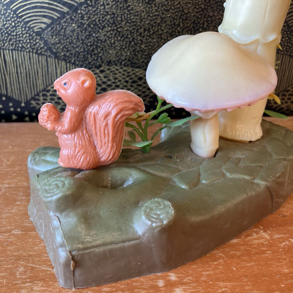 Squirrel and mushroom figurine on a stone base with a textured background