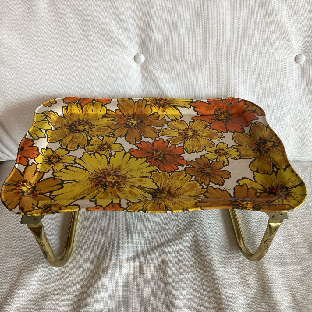 Floral-patterned tray with brass handles on a white background