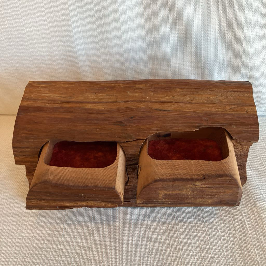 Wooden box with two red lined compartments on a textured surface