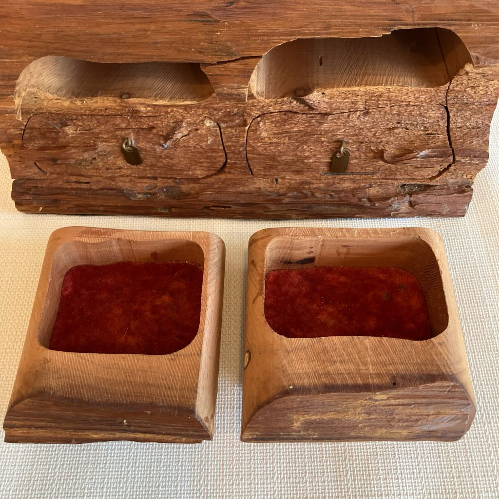 Two wooden containers with red contents inside, placed on a textured surface.