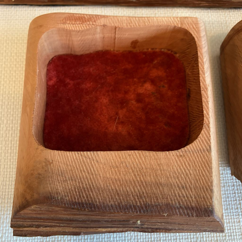 Wooden container with red substance on a textured surface