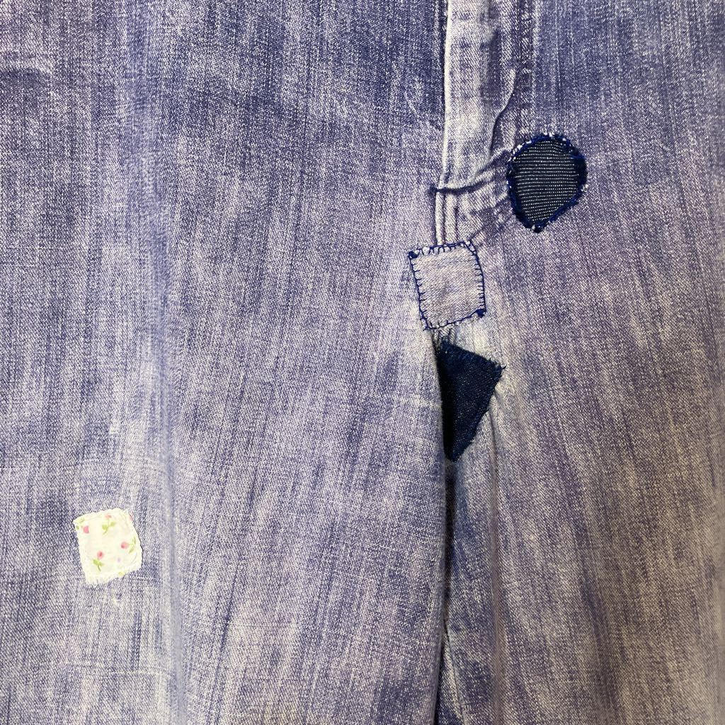 Close-up of a denim fabric with a button and stitching detail