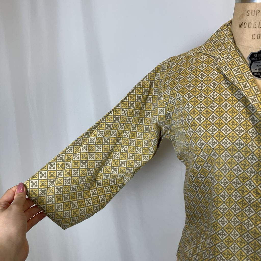 Yellow patterned shirt on a mannequin with a white background