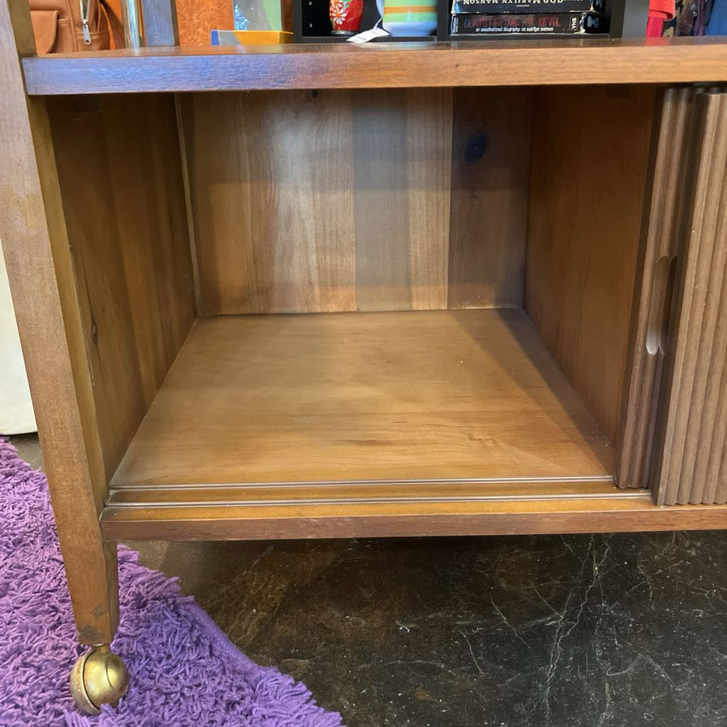 Wooden shelf with a purple rug and dark floor