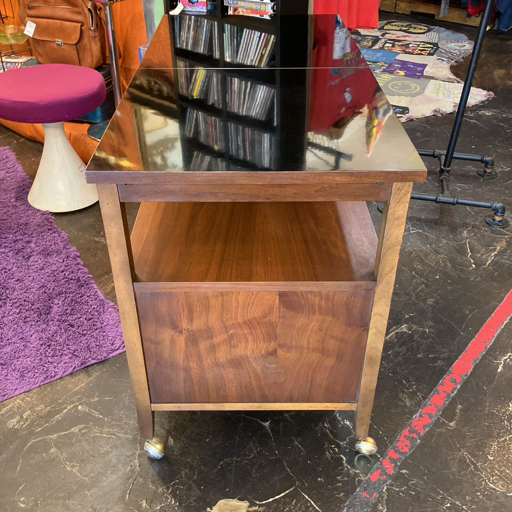 Wooden side table with glass top in a store setting