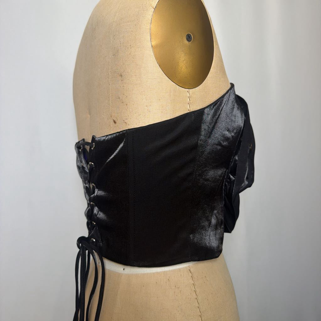 Photo of a black corset top with flower design on a mannequin against a white background