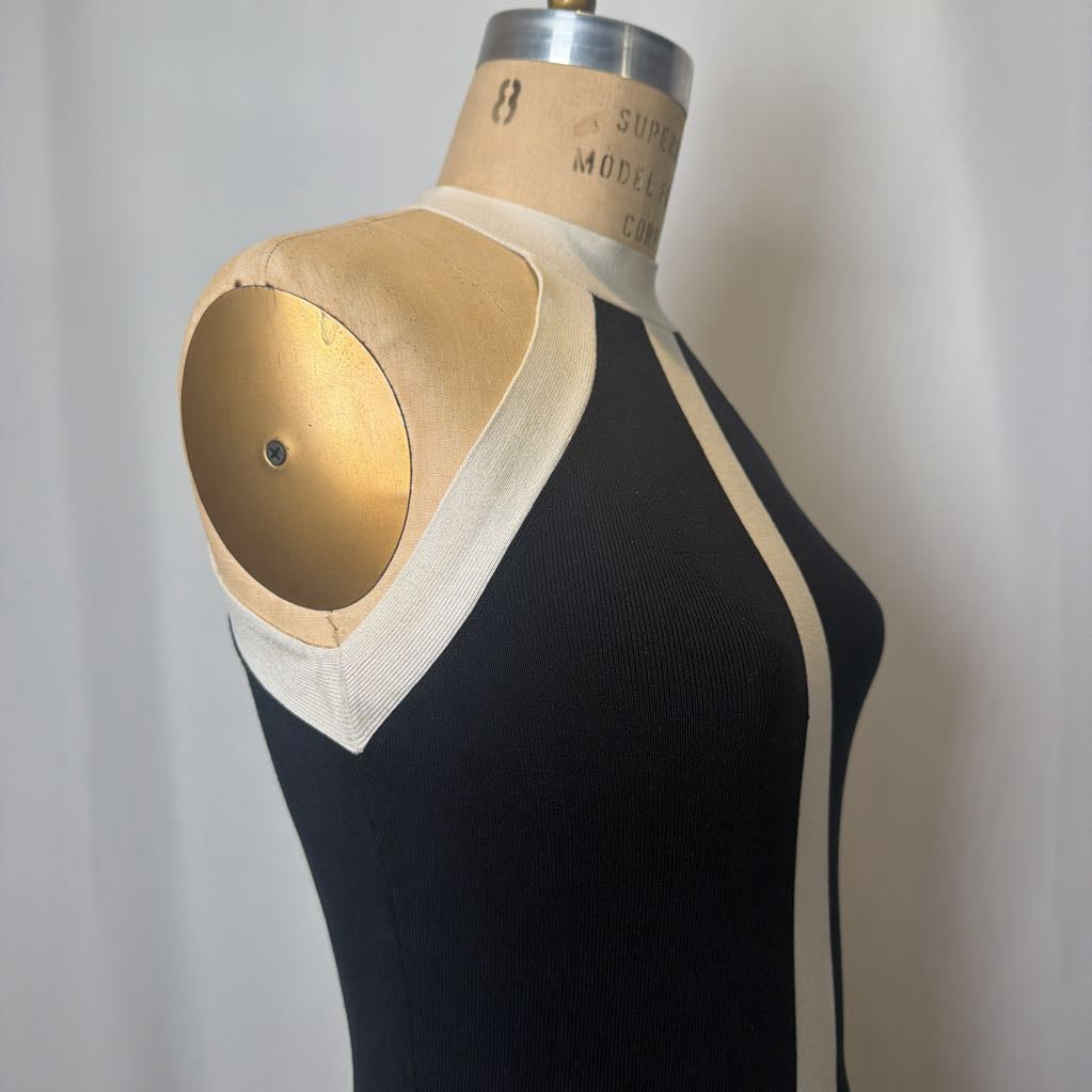Mannequin torso with black dress and beige collar on a plain background