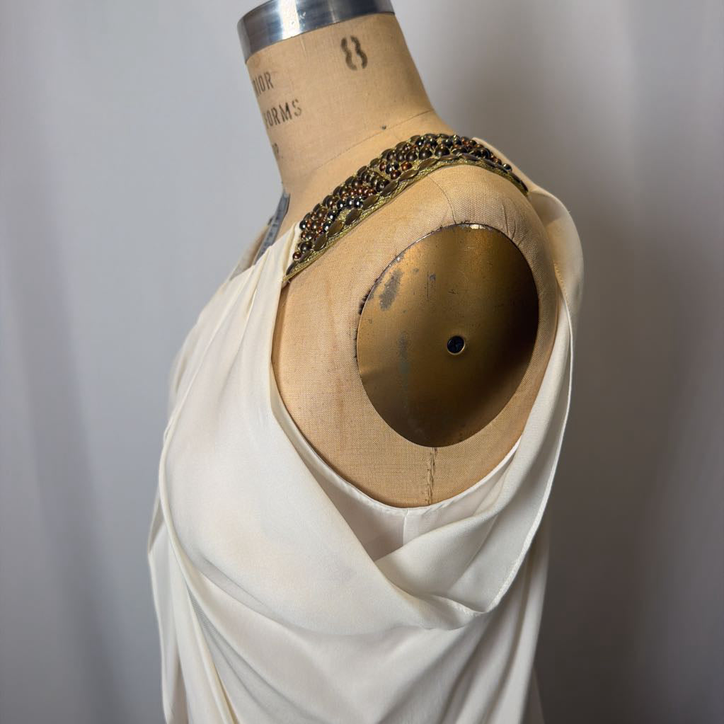 Mannequin torso with white fabric draped over it, wearing a decorative headband.