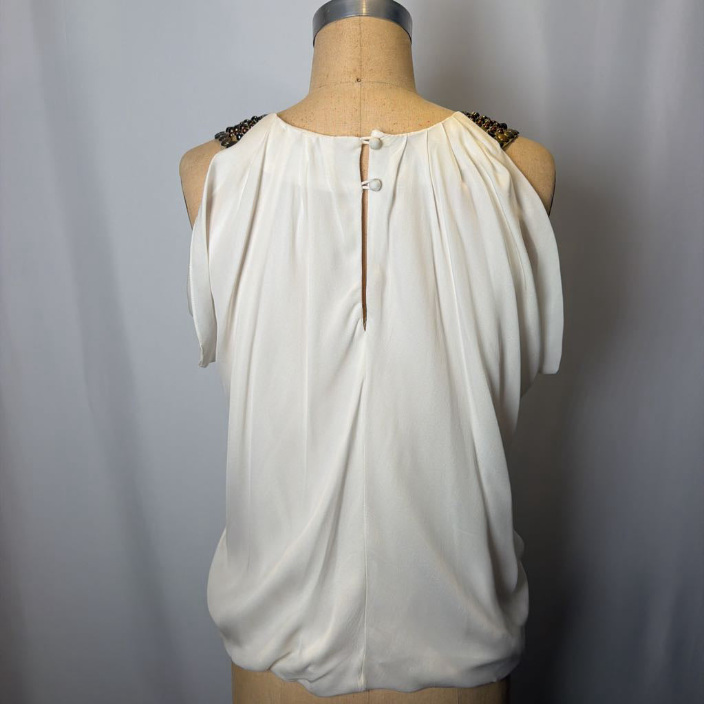 White sleeveless top on a mannequin against a plain background