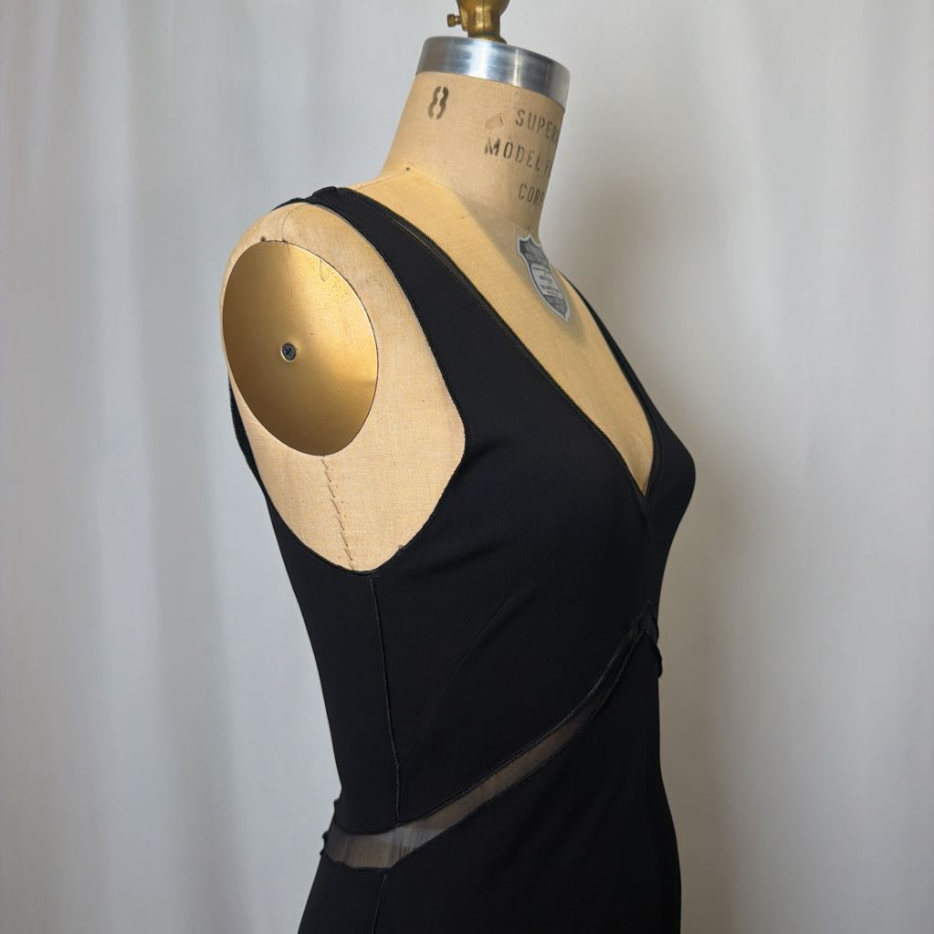 Black dress on a mannequin against a plain background