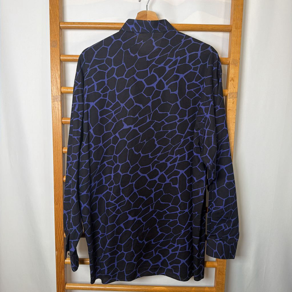 Blue and black patterned shirt on a wooden hanger against a white background