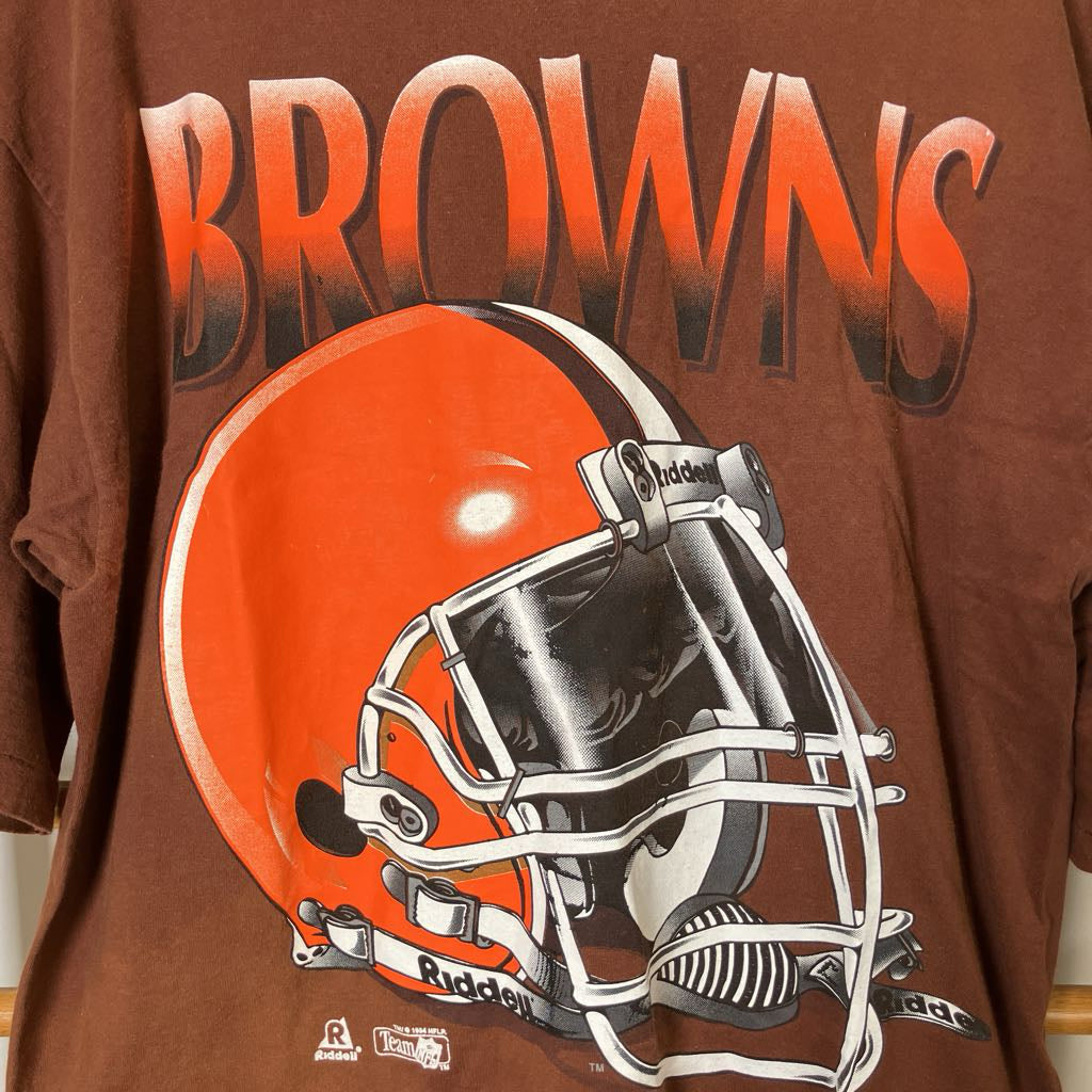 Brown t-shirt with a football helmet graphic and 'Browns' text on a wooden rack.